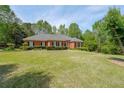 Ranch style home with a lush green lawn and mature trees at 1420 Arblay Pl, Loganville, GA 30052