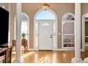 Elegant foyer with hardwood floors, decorative columns, arched windows and a stunning chandelier at 1420 Arblay Pl, Loganville, GA 30052