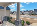 Charming front porch with stone accents, iron railings, and a view of the neighborhood street at 5860 Collier Bridge Ln, Hoschton, GA 30548