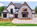 Two-story home with gray brick and white siding, featuring a three-car garage at 1095 Lanier Pl, Cumming, GA 30041