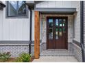 Dark wooden front door with glass panels, flanked by gray brick at 1095 Lanier Pl, Cumming, GA 30041