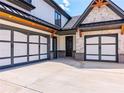 Three-car garage with gray and white doors and a large driveway at 1095 Lanier Pl, Cumming, GA 30041