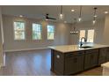 Open kitchen with island, white quartz countertops, and gray cabinets at 3311 Cranston Ln, Kennesaw, GA 30144