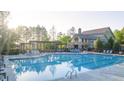 A view of the community pool with comfortable lounging spaces and a clubhouse overlooking it at 237 Laurel Vista Dr, Canton, GA 30114