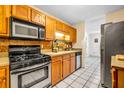 Galley kitchen with wood cabinets, stainless steel appliances, and tile floor at 5392 Brickleberry Way, Douglasville, GA 30134