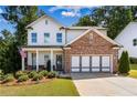 Two-story home with brick and white siding, landscaped lawn, and driveway at 253 N Gwinnett St, Buford, GA 30518