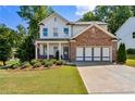 Two-story house with brick and white exterior, landscaping, and driveway at 253 N Gwinnett St, Buford, GA 30518