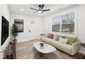 Bright living room featuring a ceiling fan, many windows, a comfortable couch, and a modern coffee table at 1288 Almont Sw Dr, Atlanta, GA 30310