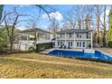 This backyard has an in-ground pool, covered patio area and well-manicured lawn at 837 Pine Ridge Dr, Lawrenceville, GA 30043