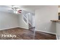 Open-concept living room with dark wood floors, ceiling fan, and carpeted staircase at 2295 Creekview Trl, Decatur, GA 30035