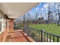 Covered front porch with brick flooring and a view of the large front yard at 7034 Capps Ferry Rd, Douglasville, GA 30135