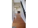 Inviting hallway with hardwood floors leading to a spacious living area with fireplace and abundant natural light at 520 Millbrook Village Dr, Tyrone, GA 30290