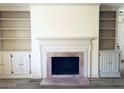 Living room fireplace with built-in shelving and hardwood floors at 134 Amherst Nw Pl, Atlanta, GA 30327