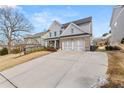 Two-story home with gray siding, brick accents, and a three-car garage at 91 N. Harris St, Buford, GA 30518