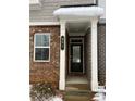 Townhome's front entrance with black door and brick facade at 397 Danville Ave, Suwanee, GA 30024