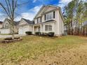 Two-story house with beige siding, two-car garage, and landscaped lawn at 129 Baywood Xing, Hiram, GA 30141