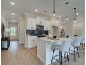 Modern kitchen with white cabinetry, quartz countertops, and a breakfast bar at 747 Trevett Way, Marietta, GA 30062