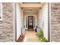 Charming front entry with stone accents, leading to a dark wood front door with wreath and decorative accents at 3430 Summerpoint Xing, Cumming, GA 30028