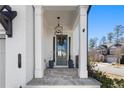 Charming front porch with stone flooring, a gray door, and white brick at 1 Ganel Ln, Alpharetta, GA 30009