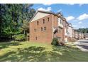 Side view of townhome showcasing brick exterior, deck, and grassy yard at 3155 Boldmere Se Trl # 3, Smyrna, GA 30080