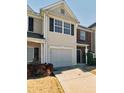 Two-story townhome with a large garage door and landscaping at 520 Dragonfly Ct, Cumming, GA 30040