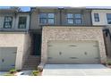 Charming two-story townhome featuring a two-car garage and stylish brick and siding exterior at 1356 Lucan Ln # Wc226, Lawrenceville, GA 30043
