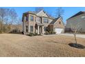 Two-story house with brick and siding, showcasing a large front yard at 8015 Brewton Creek Dr, Cumming, GA 30028