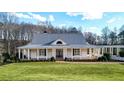 White farmhouse with gray metal roof, large windows, and a spacious lawn at 5288 East Cherokee Dr, Canton, GA 30115