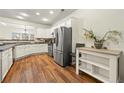 Well-lit kitchen featuring stainless steel appliances, white cabinetry, and beautiful hardwood floors at 1503 Dolcetto Nw Trce # 2, Kennesaw, GA 30152