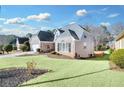 Side view of the house showcasing its brick facade and yard at 185 Glen Holly Dr, Roswell, GA 30076