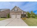 Two-story home with stone and shingle accents, two-car garage, and landscaped front yard at 5960 Overlook Club Cir, Suwanee, GA 30024