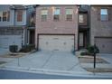 Charming townhome with brick facade, two-car garage, and well-maintained landscaping at 3280 Hallmark Ln, Buford, GA 30519