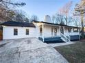 Newly renovated home featuring a white exterior, front porch, and landscaped yard at 1626 Saddlecreek Rd, Auburn, GA 30011