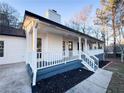 Newly renovated home featuring a white exterior, front porch, and landscaped yard at 1626 Saddlecreek Rd, Auburn, GA 30011