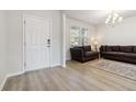 Bright living room with hardwood floors, a white front door, and plush sofas, perfect for relaxation at 2131 Landsburg Way, Lawrenceville, GA 30043