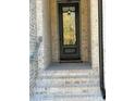 Front entry of townhome with brick steps and black door at 1346 Lucan Ln # Wc227, Lawrenceville, GA 30043