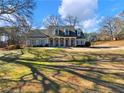 House exterior showcasing a large yard and mature trees at 4248 Hog Mountain Rd, Hoschton, GA 30548
