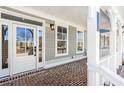 Front porch with brick flooring and white columns at 152 Palm St, Holly Springs, GA 30115