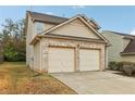 Two-story house with beige siding, brick accents and a two-car garage at 6057 Hemperly Rd, Atlanta, GA 30349