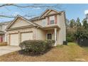 Two-story house with beige siding, brick accents, and a two-car garage at 6057 Hemperly Rd, Atlanta, GA 30349