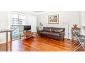 Living room features hardwood floors and a brown leather sofa at 275 13Th Ne St # 1106, Atlanta, GA 30309