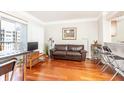 Living room boasts hardwood floors and a brown leather sofa with balcony access at 275 13Th Ne St # 1106, Atlanta, GA 30309