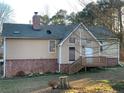 Tan house with brick base, deck and mature trees at 5078 Hubert Dr, Powder Springs, GA 30127