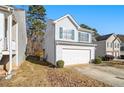 Two-story house with a white exterior, two-car garage, and side yard at 4260 Wesley Hall Dr, Decatur, GA 30035