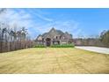 Large two-story home with stone and brick exterior and a spacious lawn at 7519 Waterview Cv, Douglasville, GA 30135