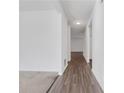 Long, white hallway with dark floors and light colored carpet at 4770 Marco Ln, Cumming, GA 30028