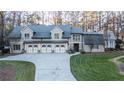 Four-car garage, gray exterior, and manicured lawn at 315 Brandenburgh Cir, Roswell, GA 30075