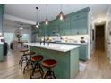Charming kitchen with a center island, pendant lighting, modern appliances, and green cabinetry at 4492 Bryten Dr, Douglasville, GA 30135