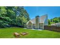 Large backyard with fire pit, wooden bench and fenced perimeter at 6196 Windflower Dr, Powder Springs, GA 30127
