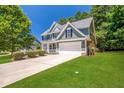 Green two-story house with a two-car garage and spacious lawn at 6196 Windflower Dr, Powder Springs, GA 30127